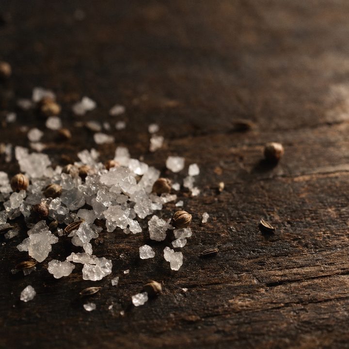 Pale crystals scattered on dark wood.