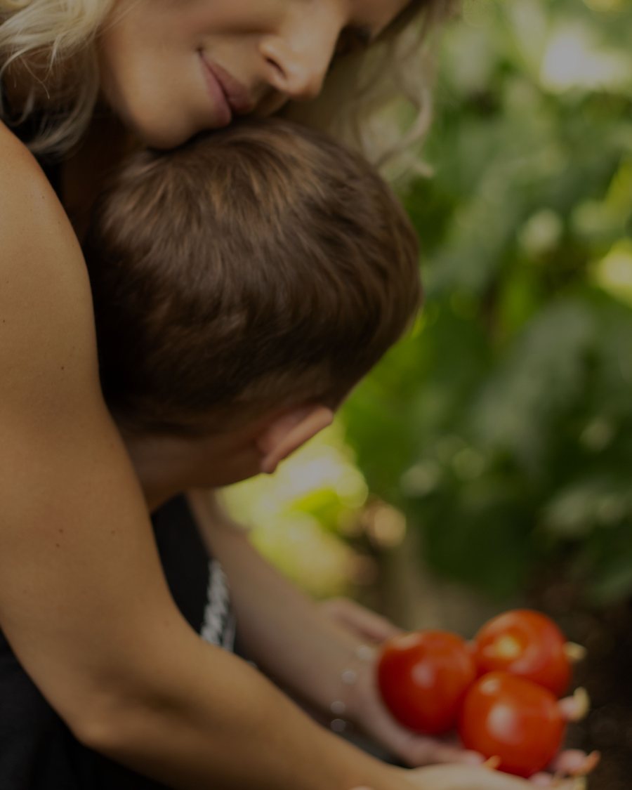 Valentino held close in the garden, a handful of ripe tomatoes.